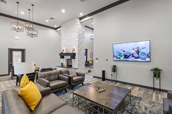 A modern living room with a stone fireplace and a flat screen TV.